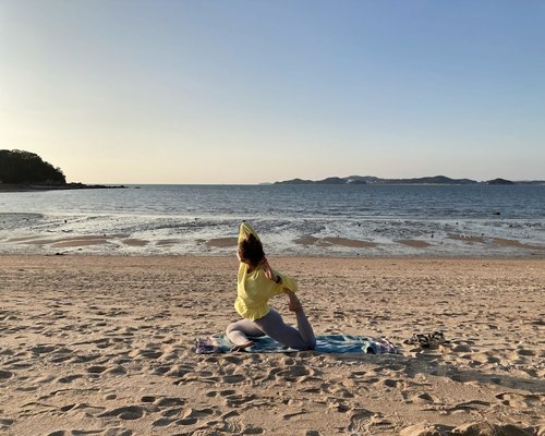Person practicing yoga meditation outdoors at sunset